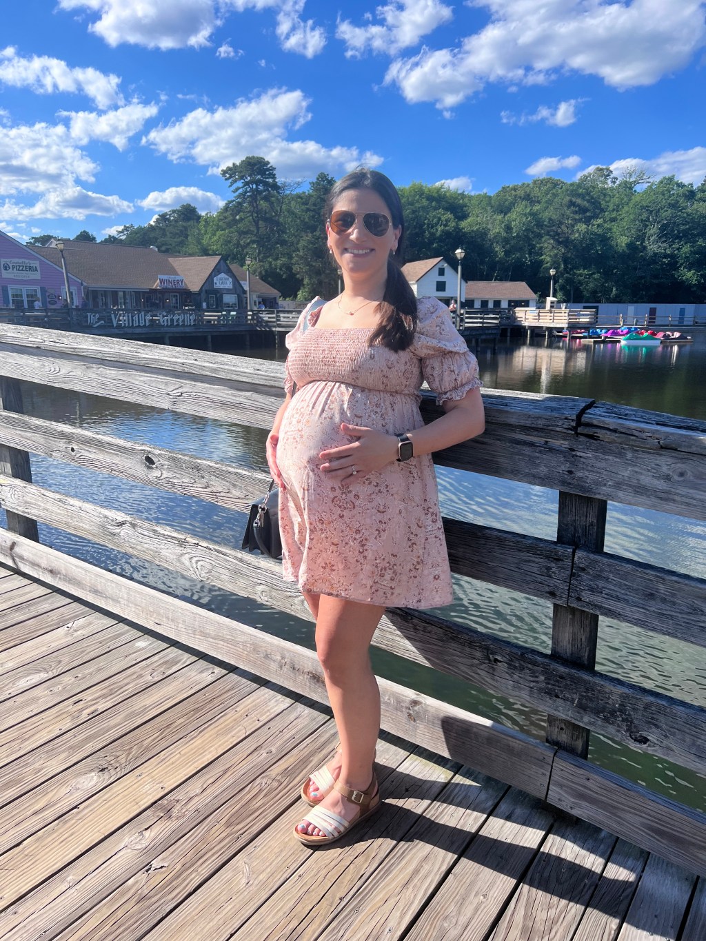 Pregnant woman standing outdoors, 8 months pregnant with her rainbow baby, embracing the journey of healing and motherhood.